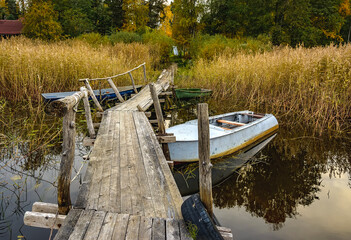An old wooden pier on the shores of Lake Vuoksa with boats tied to it.
