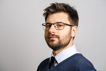 Portrait of one adult caucasian man 30 years old with beard and eyeglasses looking to the camera in...