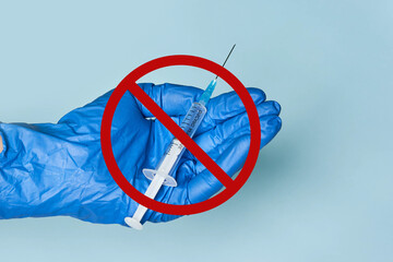 Doctor holding a vaccine syringe with the prohibited sign, concept of anti-vaccination, anti...