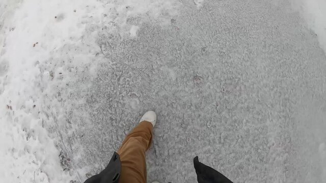 Man walking on ice frozen on the street during the winter in Canada.