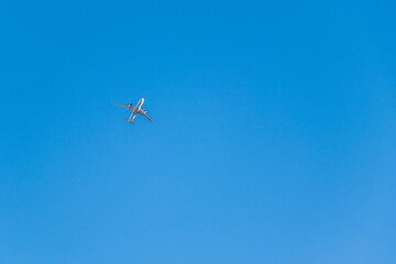 快晴の空を飛ぶ白い飛行機