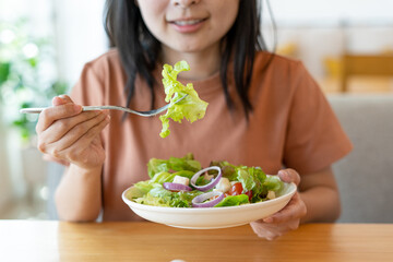 Diet. The smiling woman enjoys eating a salmon salad. To lose weight and diet, eat foods that are beneficial to the body. Weight loss concept.