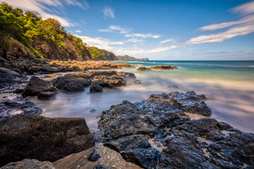 Fototapeta na wymiar Long exposure, pacific ocean waves on rock in Playa Ocotal, El Coco Costa Rica