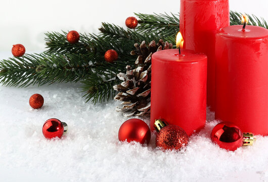 Candele di Natale rosse decorate con rami di abete e ornamenti. Biglietto natalizio. Copia spazio.