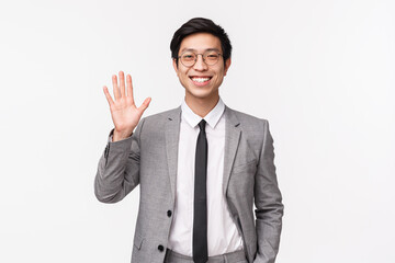 Waist-up portrait of friendly, cheerful smiling asian male entrepreneur, office worker saying hi, greeting coworker waving hand in hello, welcome gesture, standing white background - Powered by Adobe