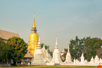 The yellow pagoda is in the group of white pagodas.