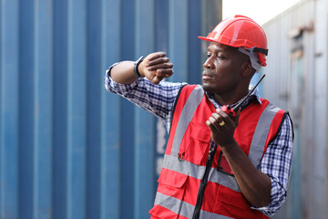 Foreman look and speak to wristwatch control loading containers box. Professional engineer or...