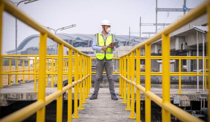 Worker under checking the waste water treatment pond industry large to control water support industry.	