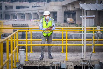 Worker under checking the waste water treatment pond industry large to control water support industry.	