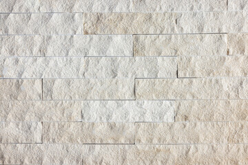 A background or texture of a natural stone wall with soft beige colors