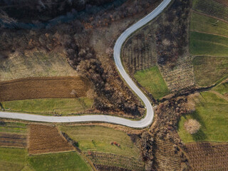 Aerial view top down from above on the country road in mountain range in between green grass and trees around - nature travel concept drone photo on Stara Planina Old Mountain in Europe SerbiaAerial v