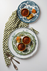 Tasty cupcakes with orange and nuts in vintage plates on a white table. Top view. Decorated with textiles and cutlery