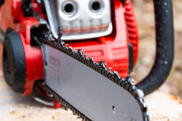 Close up of a hand gasoline chainsaw. Working tool for trimming trees.