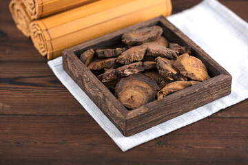 Chinese medicine rhubarb next to bamboo slips in wooden box