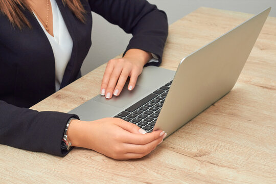a business girl with a laptop.  A close-up image of a young professional female manager using a laptop in her office, a businesswoman working at home using a laptop computer writing on a keyboard