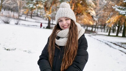 Young beautiful caucasian woman goulash in snowy winter park close up in slow motion. Happy girl...