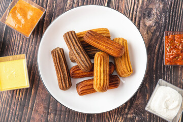 Churros with curry, olives and tomato paste on wooden table with Turkish tea