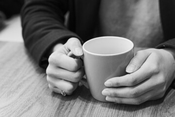 ホットコーヒーで温まる女性の手