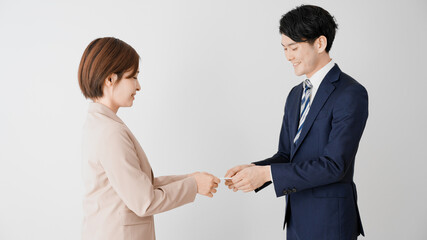 名刺交換をするビジネスマンとビジネスウーマン