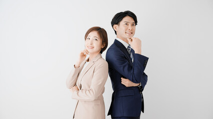 背中合わせで立つビジネスマンとビジネスウーマン