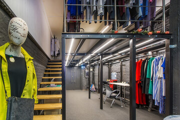 A large loft-style room with two floors of a showroom.