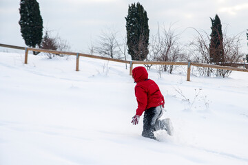 Fototapeta na wymiar Child running in a field full of snow. 