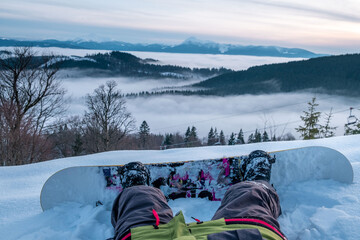 Fototapeta premium snowboarder enjoying the view of sunset above the mountains