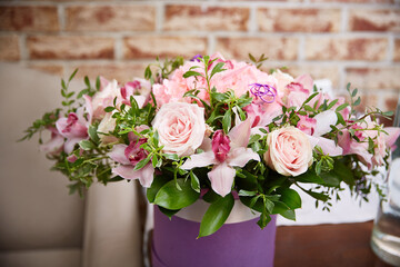 bouquet of pink roses in a festive round box on the table in the interior. A gift for a holiday, birthday, Wedding, Mother's Day, Valentine's Day, Women's Day.