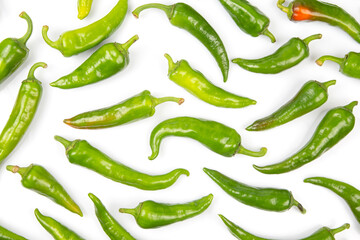 green hot peppers evenly spread on a white background. vitamin vegetables for health