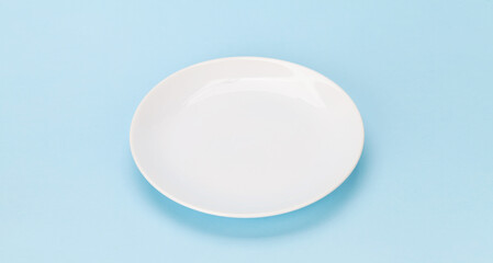 Empty white plate on blue background