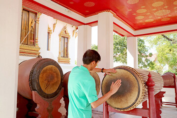 Visitor Tries Beating Old Massive Drum Made from Rosewood, Exhibited at Si Somdej Pavilion in Wat Benchamabophit (The Marble Temple), Bangkok, Thailand