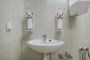 elbow soap and antiseptic dispenser or sanitizer wall mounted for hand disinfection and water tap sink with faucet bathroom or clinic