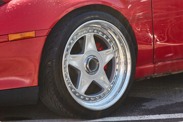 Wheel close-up on a tuned red car.