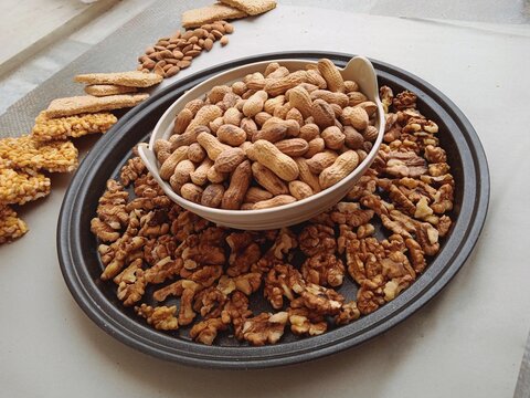 Warm picture of peanuts in a bowl with some walnuts. Useful for articles like winter foods or punjabi folk foods or some dry fruit businesses. 