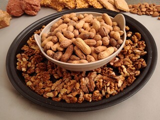 Dry fruits for winter. Groundnuts or peanuts in a bowl with some walnuts and other sweets in background. 