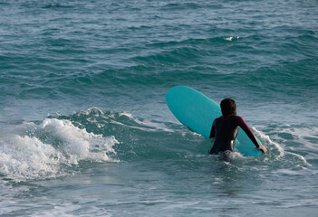 girl or woman practicing surf sport on winter season in the Poetto beach in Cagliari - Sardinia.