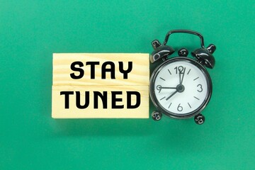 alarm clock, wooden board with the word stay tune