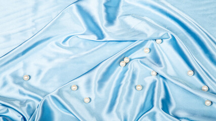 pearls on light blue luxury satin fabric. Background. elegant wallpaper