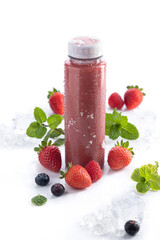 Strawberry smoothie bottle with detox superfood on white background and copy space. Vertical format. Healthy drinks concept.