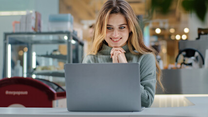 Portrait beautiful young girl student business woman female user winner looking into laptop surprised wide open mouth with delight good news applauds happiness winning opportunity new job notification