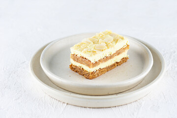 A piece of lemon cake with almonds in a plate. Sugar, gluten and lactose free and vegan.