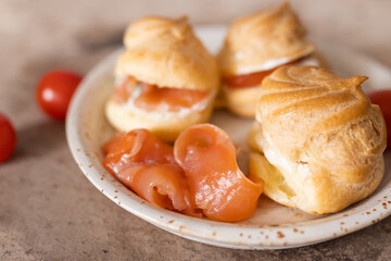 Eclairs with salted red fish and cream cheese on a white plate. Food photography.  An example of serving on a plate.