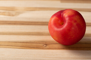 Plums, beautiful and juicy plums positioned on a rustic wooden surface, selective focus.