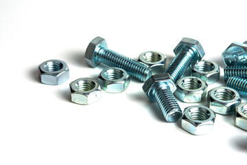 Various silver metal bolts. Fastening bolts with washers and nuts on a white background close-up. Copy space.