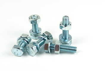 Several large silver metal bolts. Bolts, nuts and washers on a white background close up