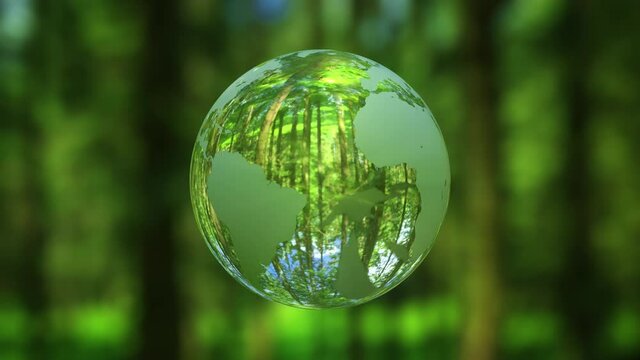 3D animation - Looped rotating crystal ball shaped planet Earth in a green forest 
