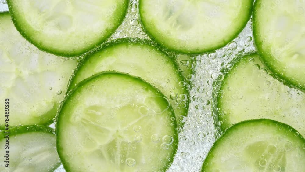 Poster slices of cucumber in water with bubbles, home made lemonade. super slow motion, filmed on high spee