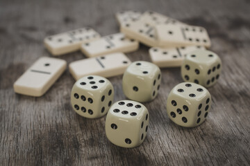Dice and dominoes on wooden table, casino luck