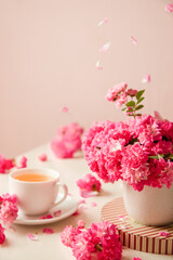 roses and tea cup served for breakfast on plain background, copy space for text, valentine's day, wedding or anniversary morning decorations. 