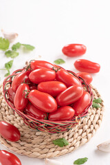 Fresh cherry tomatoes in a basket with spices.